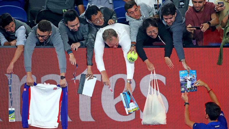 Novak Djokovic signs autographs after his fourth round win over Daniil Medvedev. Photograph: Scott Barbour/Getty Images