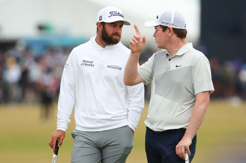 Cameron Young talks to Robert MacIntyre on the 17th green during the first round at St Andrews. Photograph: Andrew Redington/Getty Images