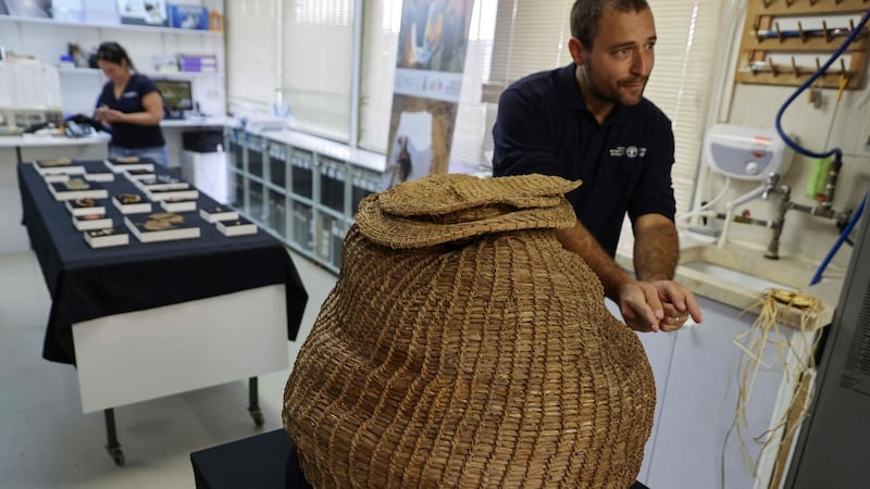 Archaeologist Naama Sukenik shows a 10,500-year-old basket dating back to the Neolithic period that was unearthed in Murabaat Cave in the Judean Desert. Photograph: Menahem Kahana/AFP via Getty Images