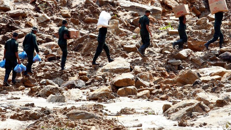 Army personnel carry food supplies and water as rescue and relief works continue after a landslide in which 35 people are feared killed at Athwelthote in Baduraliya, some 98km from Colombo, Sri Lanka. Photograph: M A Pushpa Kumara/EPA