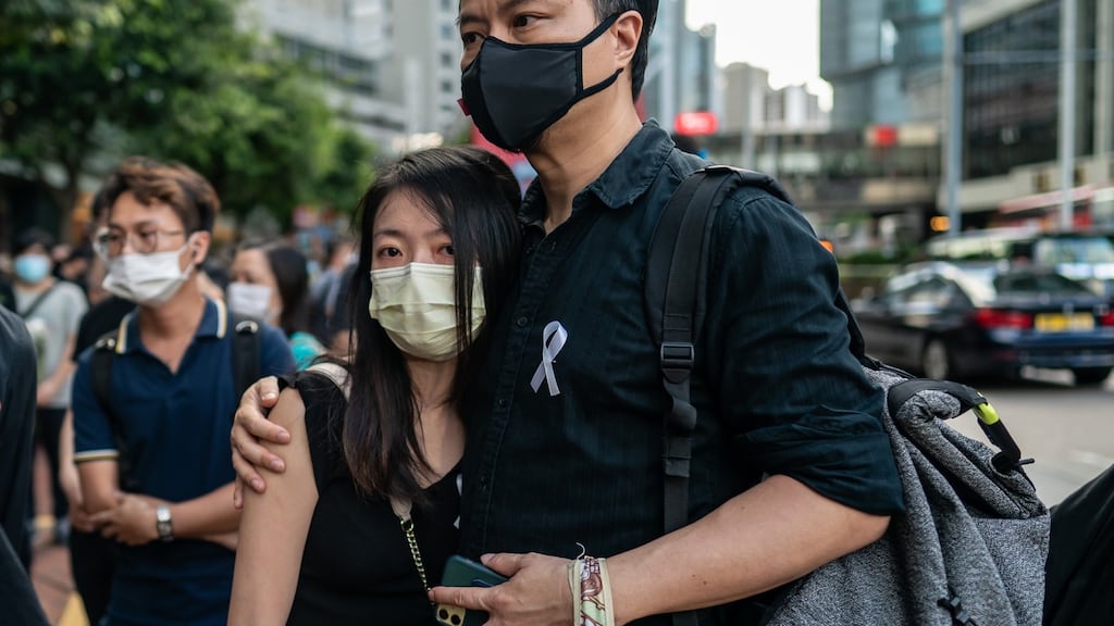 Mourners embrace during the one-year anniversary memorial vigil to commemorate Marco Ling-kit Leung at a shopping mall on June 15, 2020 in Hong Kong, China. Thousands of mourners gather to mark the one-year anniversary of the death of Leung, who fell to his death during a rally against a controversial extradition bill proposal last year. (Photo by Anthony Kwan/Getty Images)