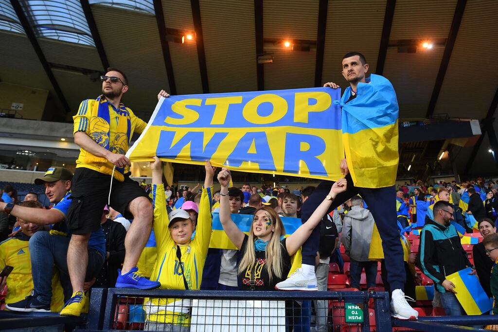 Fans draped in Ukraine national flags hold a 'Stop the War' banner during the World Cup qualifier against Scotland. Photograph: Andy Buchanan/AFP via Getty