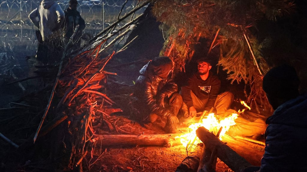 Migrants from the Middle East and elsewhere warm up at the fire gathering at the Belarus-Poland border near Grodno, Belarus, on Wednesday. Photograph: Ramil Nasibulin/BelTA via AP