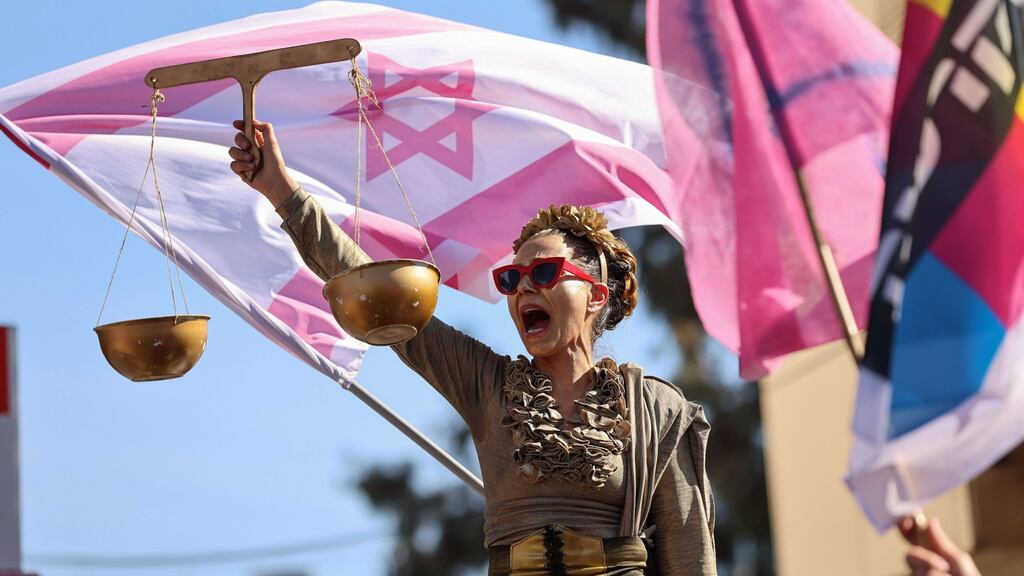 An Israeli protester dressed as Lady Justice in a demonstration outside the Jerusalem district court. Photograph: Emmanuel Dunand/AFP via Getty