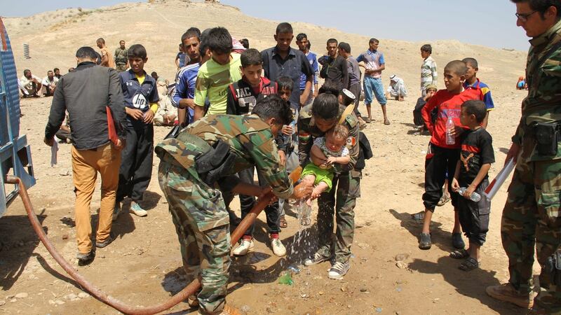Peshmerga fighters wash the feet of a displaced Iraqi child from the northern Iraqi village of Hawija as families rest under the protection of Peshmerga forces some 50km northwest of Kirkuk after fleeing from Islamic State jihadists on August 17th, 2016. Photograph: Marwan Ibrahim/AFP/Getty Images