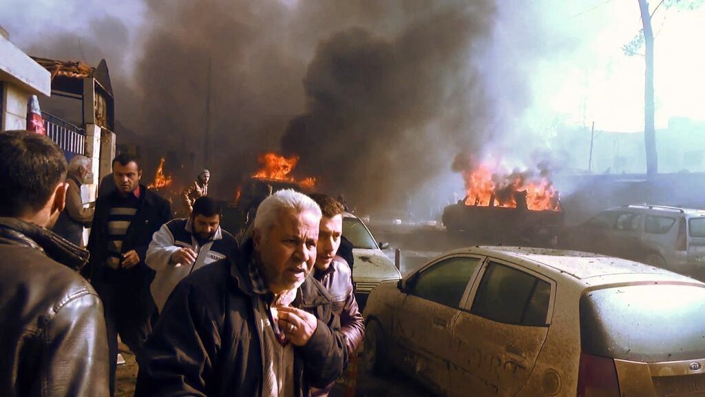 An image grab taken from an AFPTV video released on Saturday shows people gathering amidst the debris at the site of a car bomb attack in the rebel-held town of Azaz in northern Syria. Photograph: AFP/Getty Images