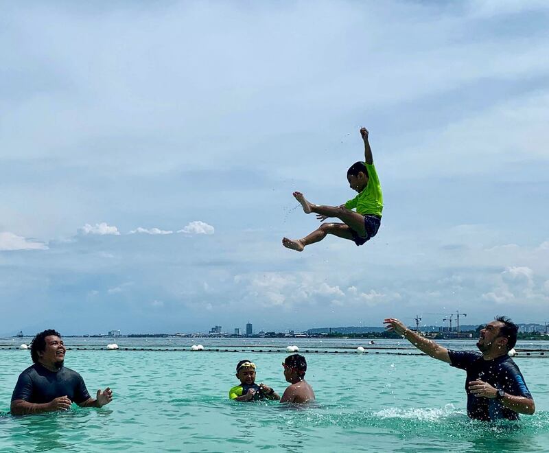 Summer Pix 2019: a child being thrown up in the sky by his father. Photograph: Ronald Gutierrez