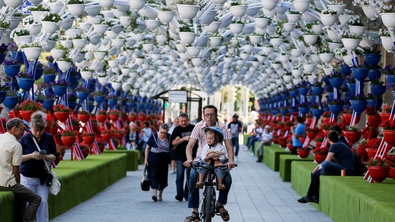 A man and a child ride a bicycle at a decorated street in central Moscow. Photograph: Photograph: Gleb Garanich