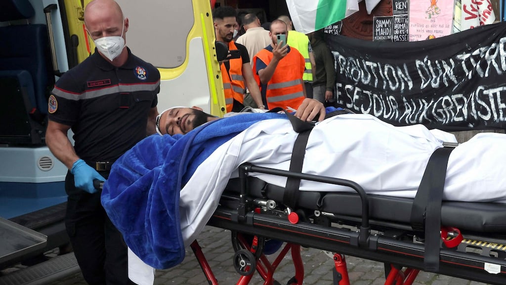 A immigrant worker on hunger strike is evacuated on a stretcher by firefighters, from the Béguinage church in Brussels on Monday. Photograph: François Walschaerts/AFP via Getty Images