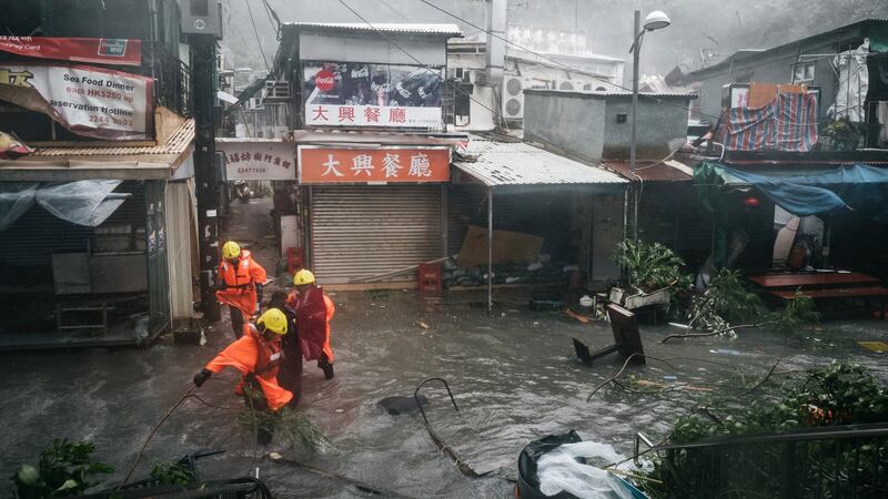 Firefighters escort people through floodwaters in Hong Kong, China. Photograph: Anthony Kwan/Bloomberg