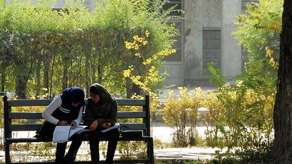 Two girls study peacefully in the grounds of Kabul University, once the scene of terrible factional fighting, on the day of the marketplace bomb depicted in this story. Photograph: Helena Mulkerns