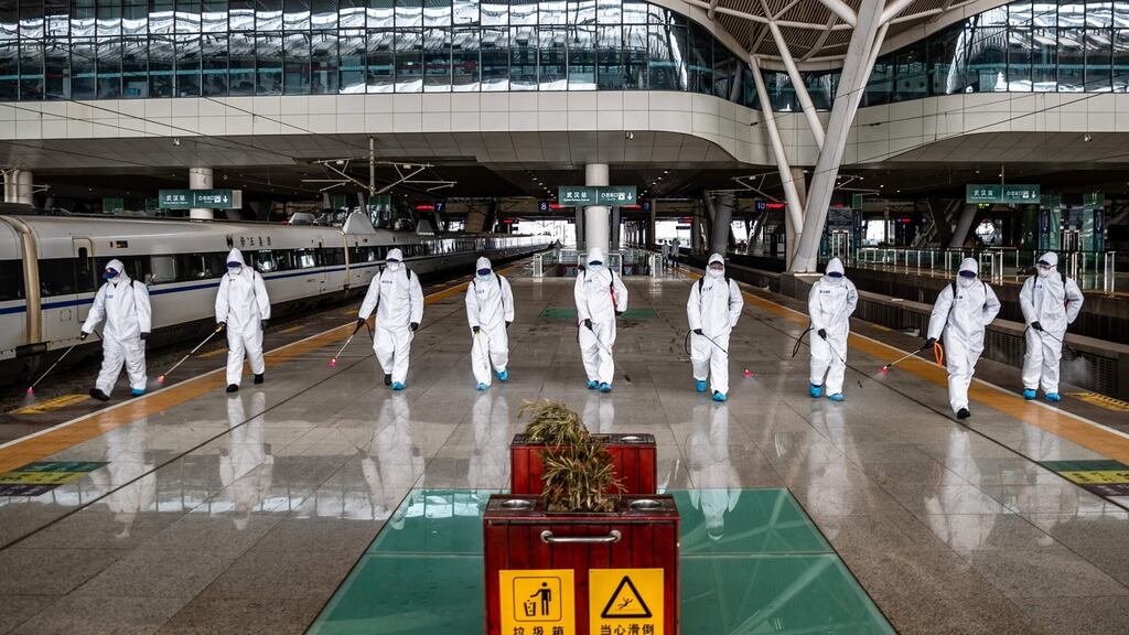 Staff members spray disinfectant at Wuhan Railway Station in Wuhan in China’s central Hubei province. Photograph: STR/AFP via Getty Images