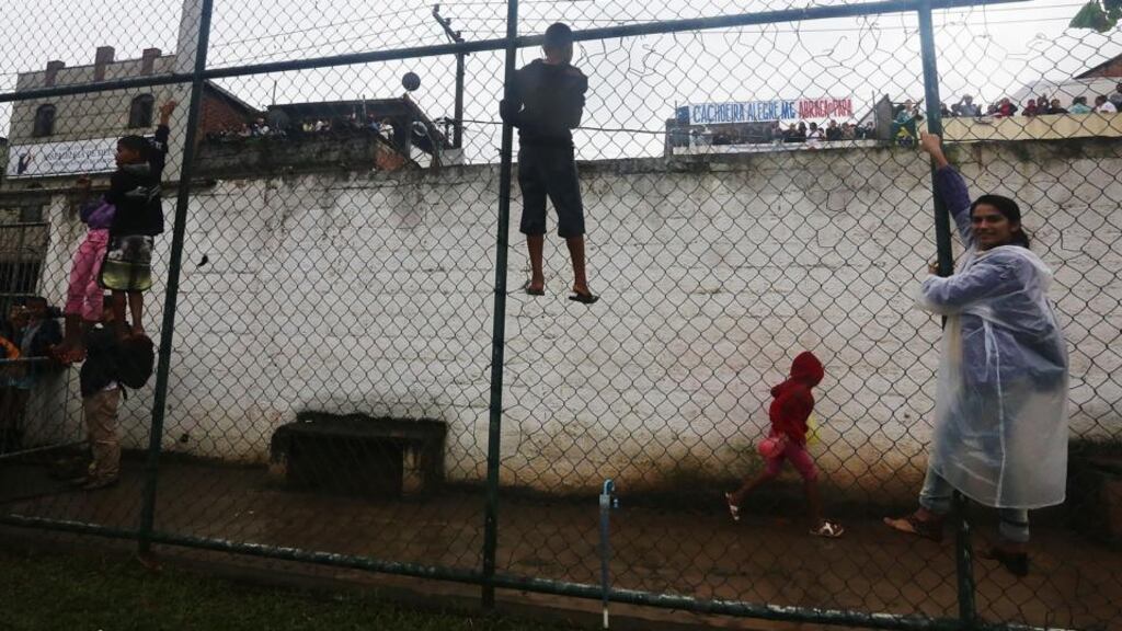 Young people cling to a fence while trying to catch a glimpse of Pope Francis in the Varginha shantytown  in Rio de Janeiro, Brazil. Photograph: Mario Tama/Getty Images)