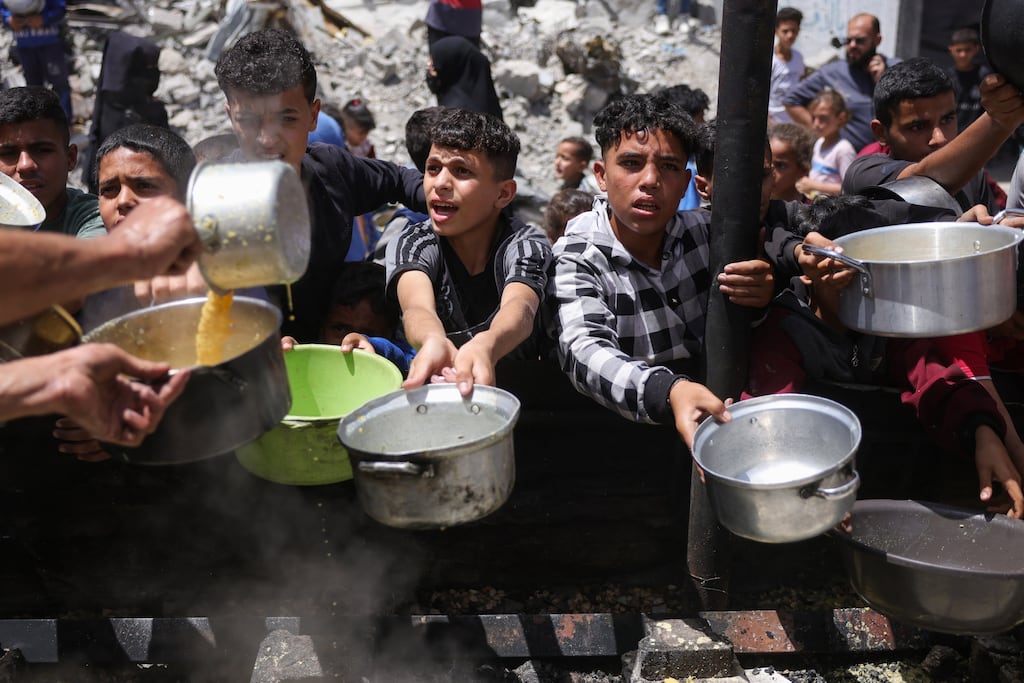 Palestinians gather to collect portions of cooked food at a charity distribution in Jabalia in the northern Gaza Strip. Photograph: Bashar Taleb/AFP via Getty Images