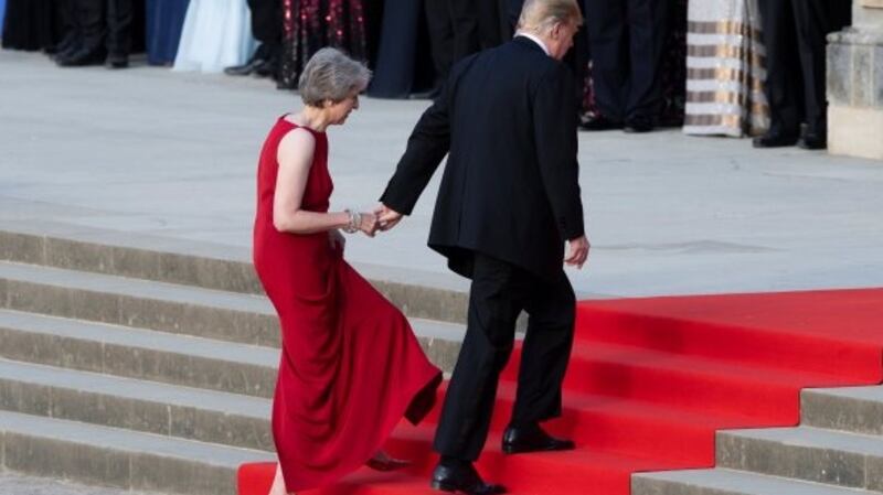 Donald Trump leads Theresa May by the hand as they climb the steps to the entrance of Blenheim Palace, where they attended a dinner this week. Photograph: Will Oliver/Reuters