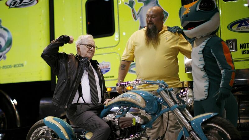 Warren Buffett poses on a motorcycle during a Berkshire Hathaway Annual Shareholders meeting in Omaha, Nebraska.