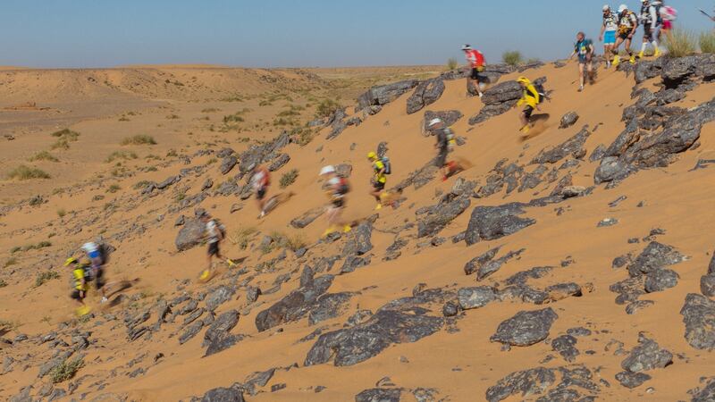 Runners descend a rock-strewn hill during the Marathon des Sables.