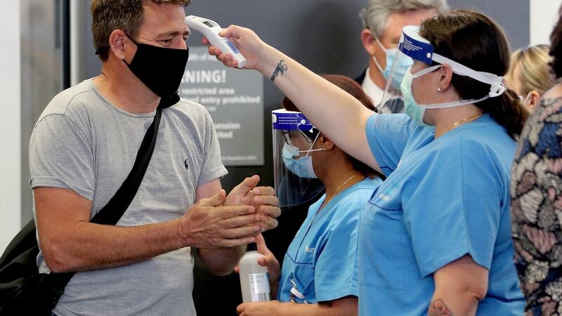 Passengers from Brisbane have their temperatures checked after arriving at Perth domestic Airport in Perth, Australia on Saturday. Long-separated West Australians are set for an emotional reunion after the state’s hard borders come down on Saturday. Photograph: Richard Wainwright/EPA