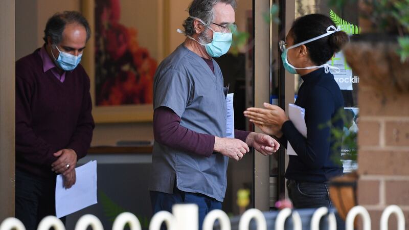 People wearing face masks are seen at the entrance of the Menarock Life aged care facility in Melbourne. Photograph: William West/AFP