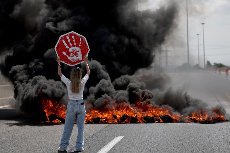 Protesters next to burning tires on the main road at Petah Tikva, Israel. Photograph: Atef Safadi/EPA