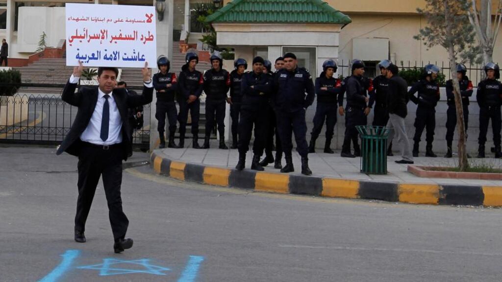Jordanian deputy Amjad Maslamani holds a placard as he walks outside the parliament to participate in a protest in Amman today. The protesters were demonstrating against the shooting of a Palestinian judge from Jordan by Israeli soldiers yesterday. The placard reads ‘No to compromise on the blood of our sons and Martyrs, expel the Israeli ambassador, Long live Arab nation’. Photograph: Muhammad Hamed/Reuters
