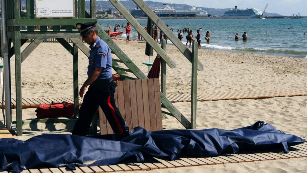 A military policeman walks next to bodies of migrants who drowned off La Playa beach in Catania in Sicily. Photograph: Reuters/Antonio Parrinello