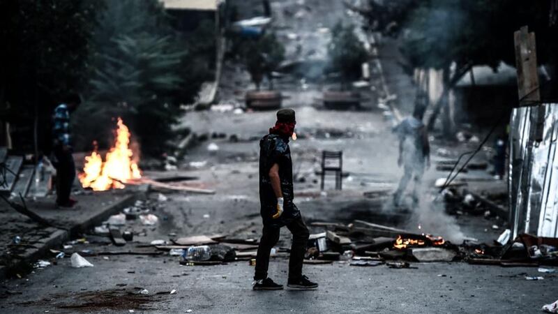 A left-wing protester waits in front of a barricade during clashes with Turkish riot police in the district of Gazi in Istanbul. Photograph: Ozan Koseozan Kose/AFP/Getty Images