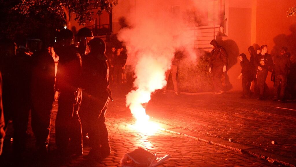 Sympathisers of squatters and German riot police illuminated by a burning flare near a housing complex in Berlin’s Rigaer Street, where a demonstration by left-wing supporters of the squatters turned tense, July 9th, 2016. Photograph: Maurizio Gambarini/EPA