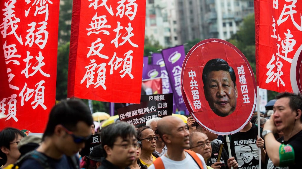 An activists holds a placard bearing a portrait of Chinese President Xi Jinping. Photograph: Isaac Lawrence/AFP/Getty Images