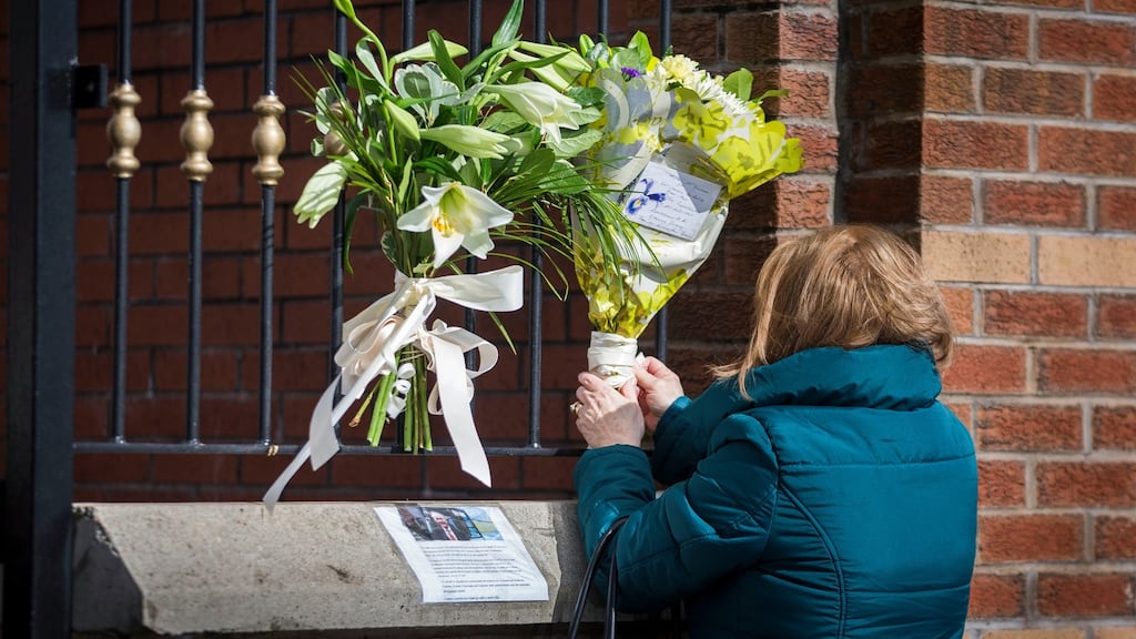 A woman leaves flowers at the gates of the Sinn Féin office at Connolly House, in Andersonstown, Belfast following the death of Martin McGuinness. Photograph: PA
