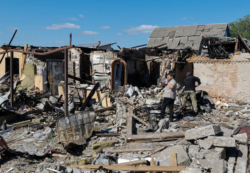 People walk through the rubble of destroyed property after an overnight rocket attack in Krasylivka village, near Kyiv, Ukraine, May 8th, 2024, as the Russian invasion continues. Photograph: Sergey Dolzhenko/EPA