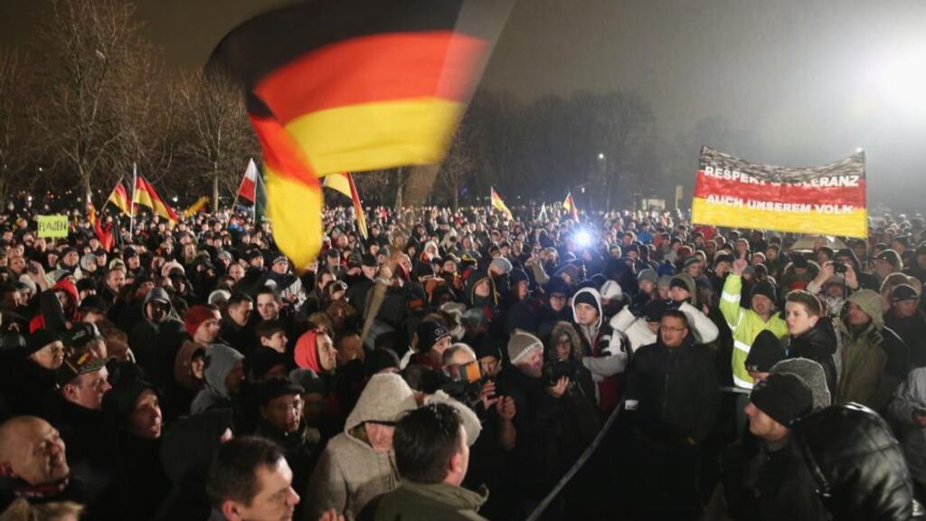 Supporters of the Pegida movement hold up German flags at another of their weekly gatherings in Dresden, Germany. Photo by Sean Gallup/Getty Images