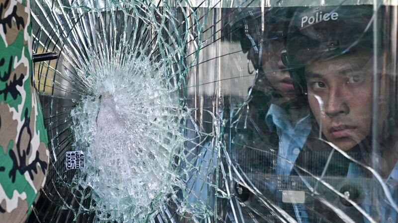 Police  inside the Hong Kong government headquarters look on at protesters who tried to smash their way into the building in. Photograph: Anthony Wallace/AFP/Getty Images