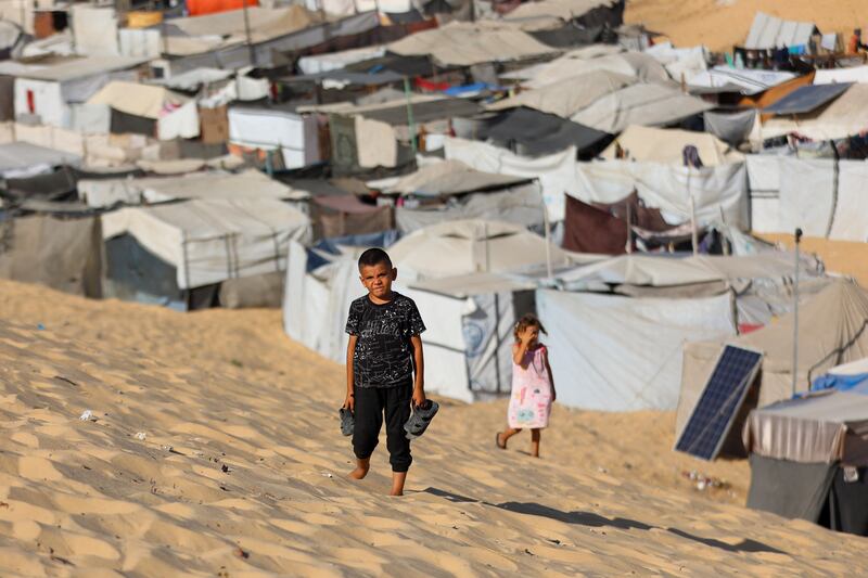 Children walk at a camp for displaced Palestinians in Khan Yunis in the southern Gaza Strip on Tuesday. Photograph: Omar Al-Qattaa/AFP via Getty Images