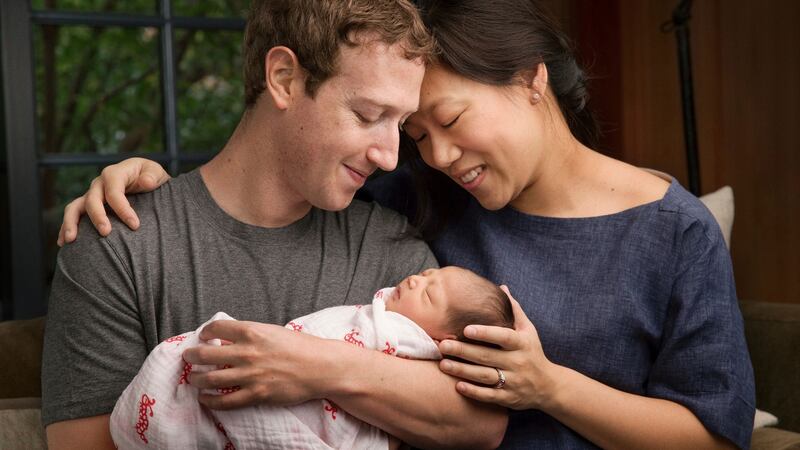 Max Chan Zuckerberg is held by her parents, Mark Zuckerberg and Priscilla Chan Zuckerberg
