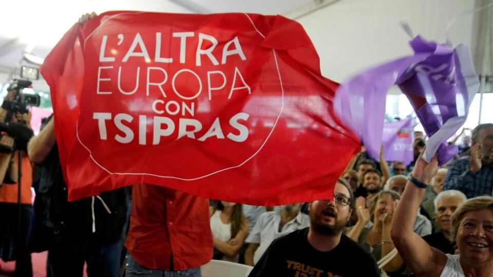 Supporters of leftist Syriza party, including someone with a banner for ‘The Other Europe’, react at the party’s main election kiosk after the announcement of the first exit polls in Athens, Greece. Photograph: Alkis Konstantinidis /Reuters