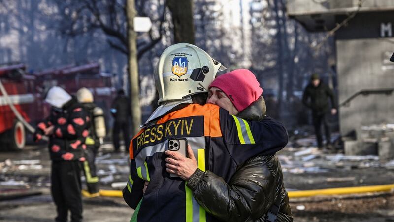 A fireman embraces a woman outside a damaged apartment building in Kyiv after strikes on residential areas. Photograph: Aris Messinis/AFP via Getty