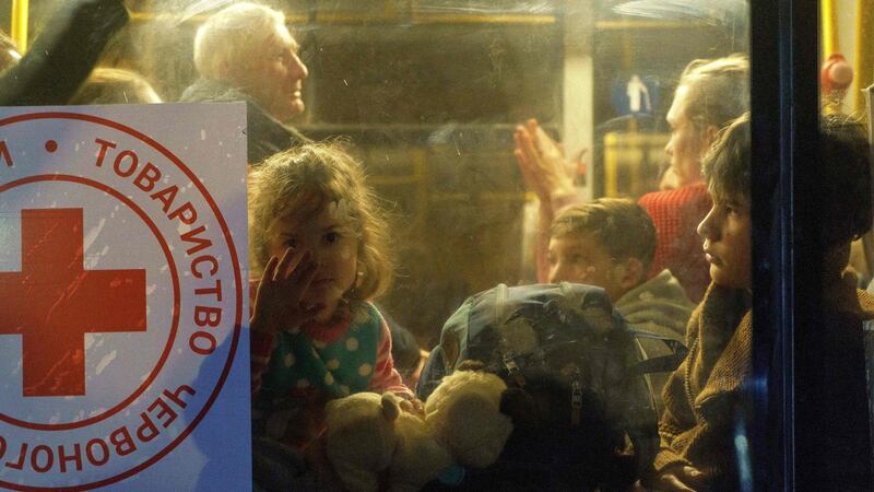 A child looks through a bus window as a convoy carrying evacuees from Mariupol and Melitopol arrive at the registration centre in Zaporizhzhia. Photograph: Emre Caylak/AFP via Getty