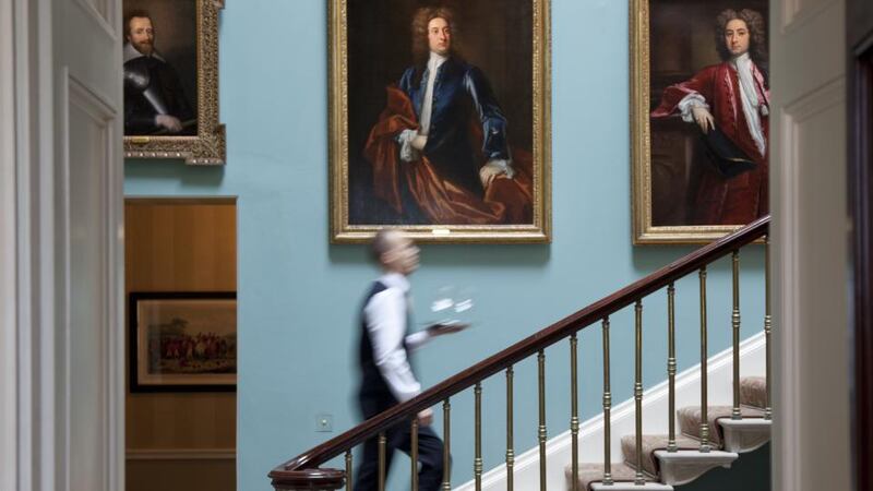 An inner hallway with the main staircase hung with portraits of Cootes through the ages