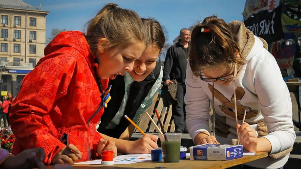Ukrainian school girls painting slogans for peace on Independence Square in Kiev earlier this week. A memorial ceremony for about 100 protesters who were killed in and around the square in the final days of president Viktor Yanukovich’s rule takes place on Sunday. Photograph: Robert Ghement/EPA