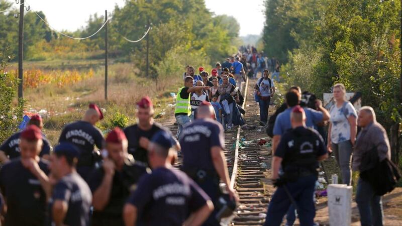 Migrants arrive along rail tracks as Hungarian police officers seal off the border with Serbia, near the Hungarian migrant collection point in Roszke, Hungary, on Monday. Photograph: Reuters