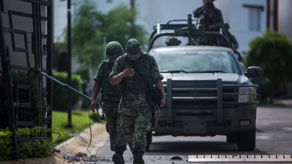 Heavily armed soldiers leave a private gated community hours after a military convoy was ambushed with grenades and high-powered guns, killing five soldiers in the city of Culiacan, Mexico. Photograph: Rashide Frias/AP