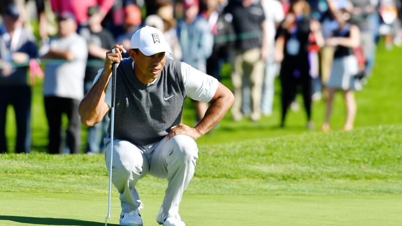 Woods prepares to putt on the first green. Photo: Donald Miralle/Getty Images