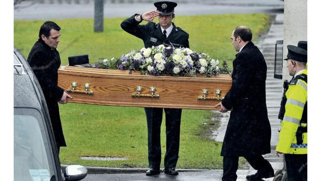 A PSNI officer salutes as the coffin of Philippa Reynolds arrives at Mossley Methodist Church in Newtownabbey Co Antrim. photograph: alan lewis/photopress