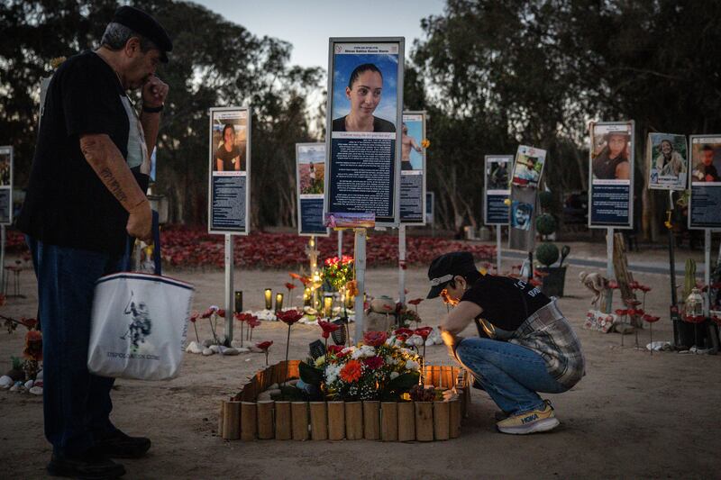People light candles at the former site of the Nova music festival where October 7th attacks took place. Photograph: Chris McGrath/Getty Images