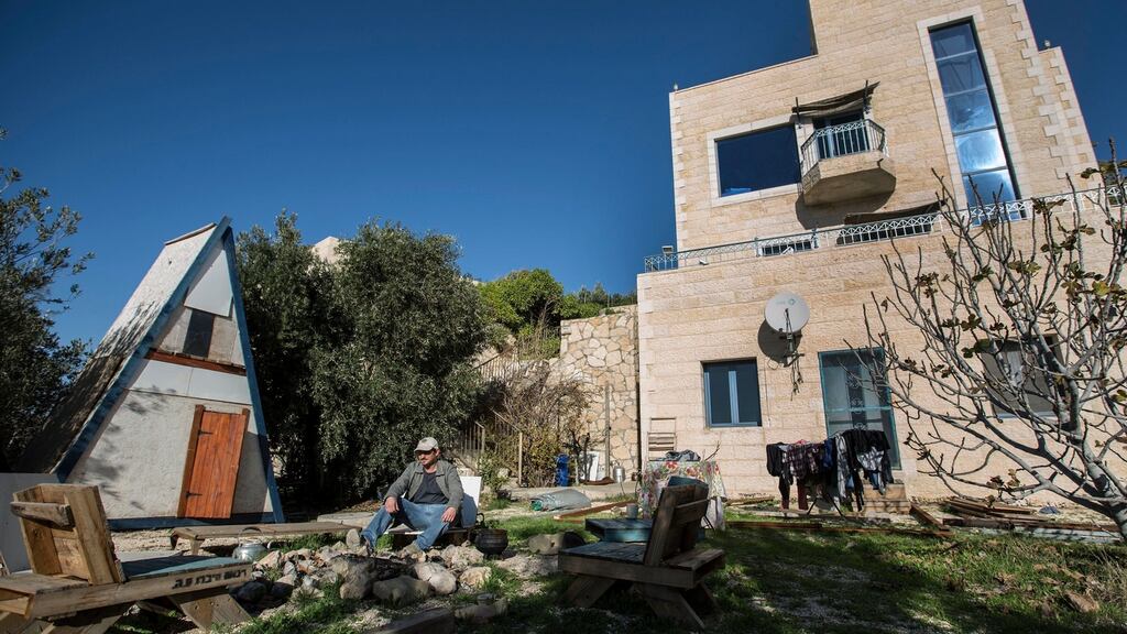 An Israeli settler sits outside his guest house, which was advertised on Airbnb, in the Nofei Prat settlement in the West Bank. Photograph: Tsafrir Abayov/AP