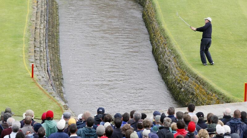 Pádraig Harrington hits over water of the Barry Burn onto the 18th green after hitting his second of two shots into the water on the 18th hole in regulation play. Photograph: Phil Noble/Reuters