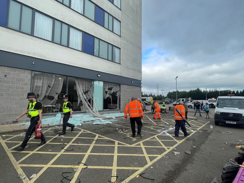 People clear debris at the Holiday Inn Express in Rotherham, South Yorkshire, where anti-immigration rioters smashed the windows before starting fires on Sunday. At least 10 officers were injured, including one who was knocked unconscious, South Yorkshire Police confirmed later, saying one person had already been arrested and others involved should "expect us to be at their doors very soon". Picture date: Monday August 5, 2024. PA Photo. See PA story POLICE Southport. Photo credit should read: Dave Higgens/PA Wire