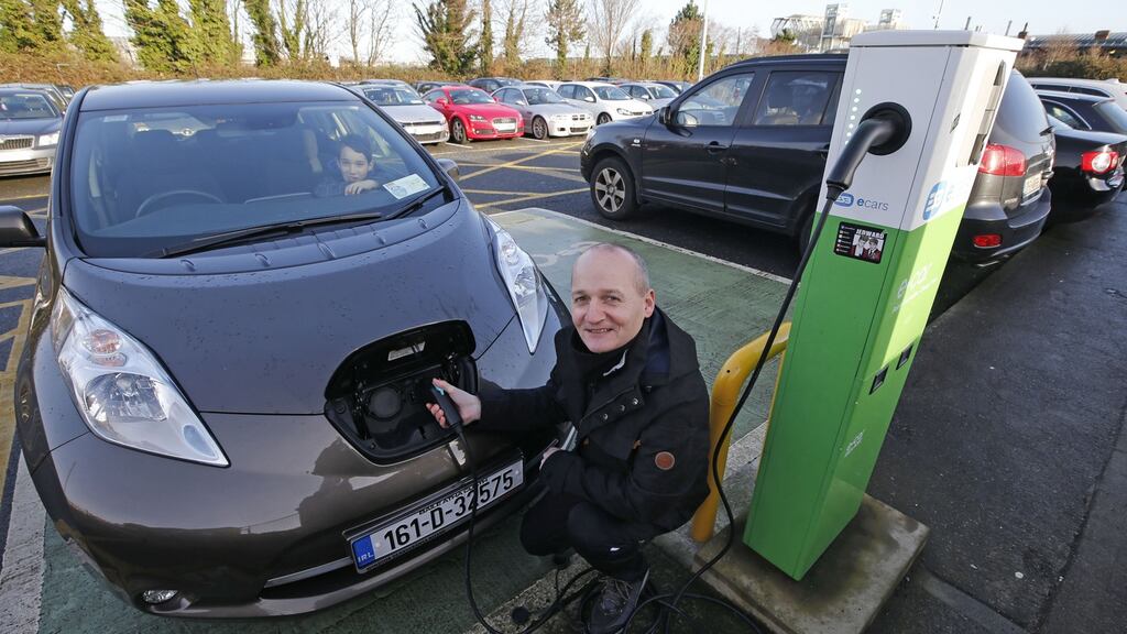 ‘Irish Times’ journalist Justin Comiskey charging his electric car at Booterstown Dart Station. The UK National Grid has warned that charging cars at home could blow main fuses. Photograph: Nick Bradshaw