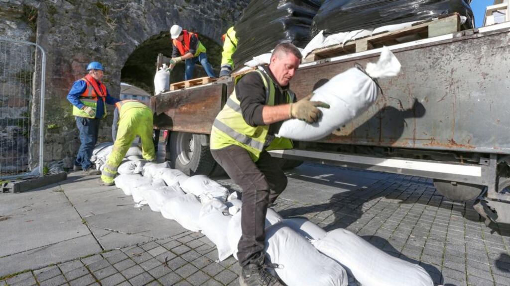 Galway City Council workers placing sandbags at the Spanish Arch to prevent flooding by high tides during storm Callum in Galway city on Thursday Photograph: Joe O’Shaughnessy